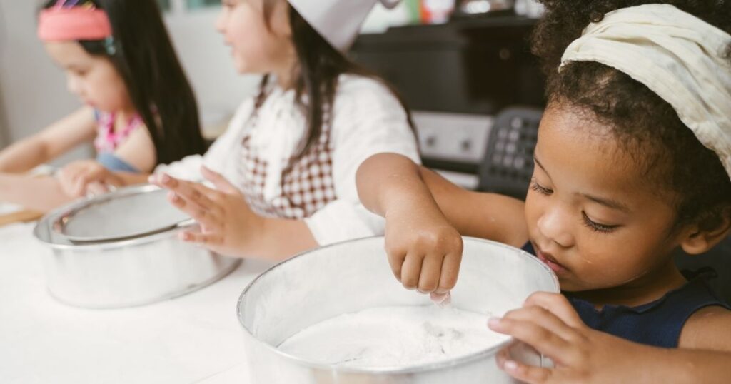 Homeschool child learning real-world math through cooking and measuring instead of using a traditional math curriculum.